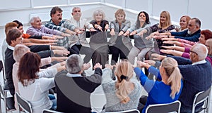 a group of mature mature people stretched their arms forward sit