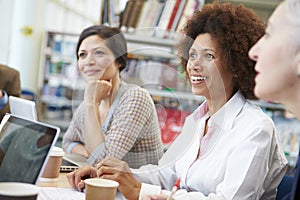 Group Of Mature Students Collaborating On Project In Library photo