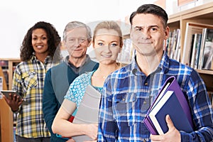 Group Of Mature Students Studying In Library