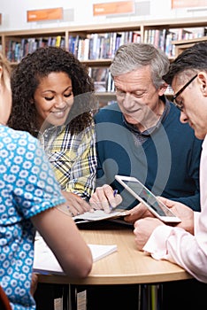Group Of Mature Students Studying In Library