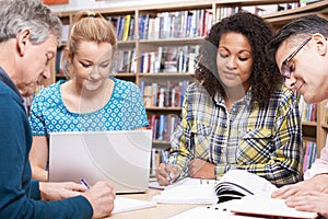 Group Of Mature Students Studying In Library