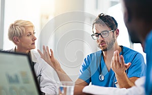 Group of medical doctors planning, brainstorming and discussing patients records in a meeting. Healthcare professional