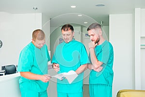 Group of medical staff discussing patient results in clinic. Healthcare professionals having discussion in hospital. Experienced