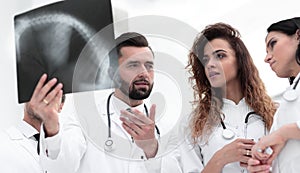 Group of medical workers looking at patient`s x-ray film