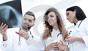 Group of medical workers looking at patient`s x-ray film