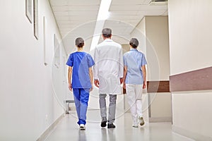 Group of medics or doctors walking along hospital