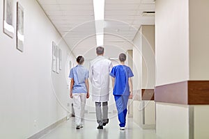 Group of medics or doctors walking along hospital