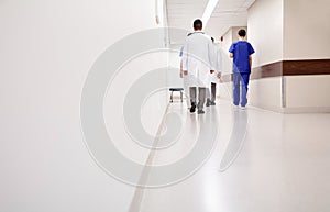 Group of medics or doctors walking along hospital