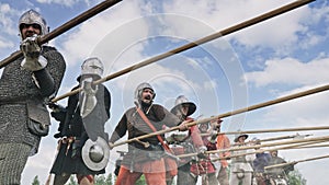 A group of medieval knights with spears preparing to attacking. Knights are dressed in medieval clothes.