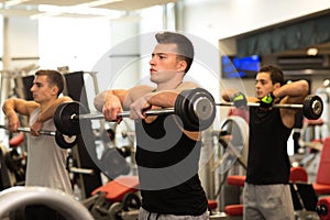 Group of men with barbells in gym