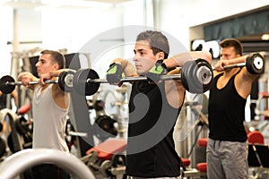 Group of men with barbells in gym