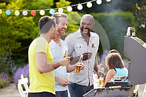 Group Of Men Cooking On Barbeque At Home