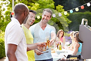 Group Of Men Cooking On Barbeque At Home