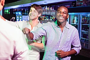 Group of men dancing near bar counter