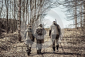 Group of men hunters going up on rural road during hunting season