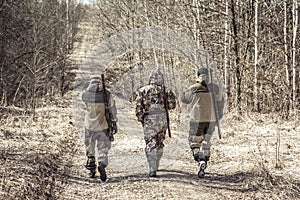 Group of men hunters outgoing on rural road during hunting season