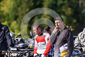 A group of men on a social gathering are preparing to ride an ATV quad bike. People Ride together on a quad atv on muddy