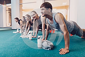 Group men and women performs a physical exercise.