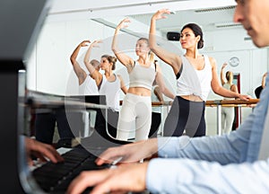 Group of men and women practicing at ballet barre