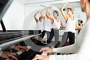 Group of men and women practicing at ballet barre