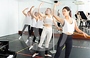 Group of men and women practicing at ballet barre