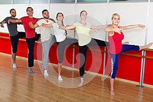 Group of men and women practicing at the ballet barre