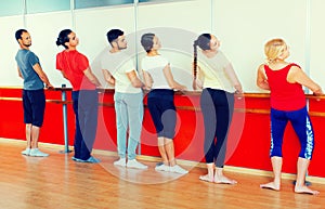 Group of men and women practicing at the ballet barre