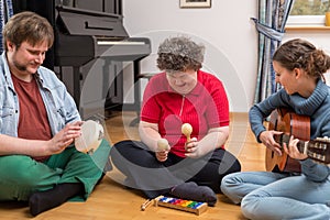 A group with a mentally disabled woman enjoys the music therapy photo