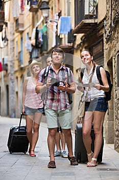 Group of merry tourists with camera and map