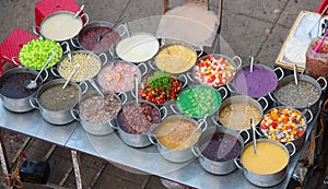 Group of metal pots on a vietnamese street stall containing various kinds of  colorful sweet soups Che hem Hue Vietnam