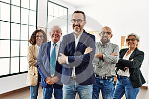 Group of middle age business workers smiling happy standing with arms crossed gesture at the office