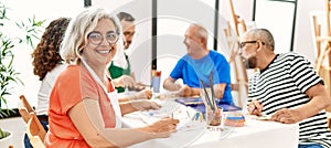 Group of middle age draw students sitting on the table drawing at art studio