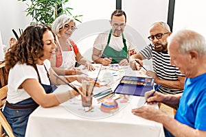 Group of middle age draw students sitting on the table drawing at art studio