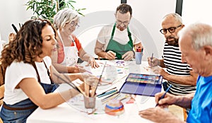 Group of middle age draw students sitting on the table drawing at art studio