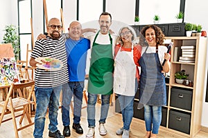 Group of middle age draw students smiling happy and hugging at art studio