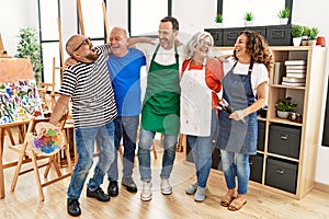 Group of middle age draw students smiling happy and hugging at art studio