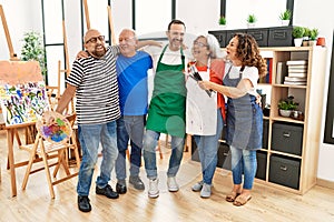 Group of middle age draw students smiling happy and hugging at art studio