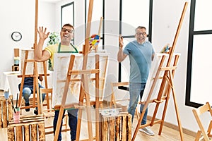 Group of middle age people artist at art studio celebrating victory with happy smile and winner expression with raised hands