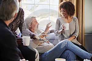 Group Of Middle Aged Friends Meeting Around Table In Coffee Shop photo