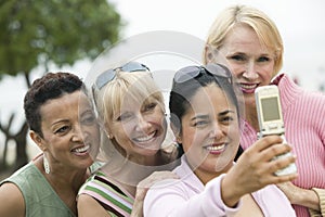 Group of middle-aged women photographing themselves with a mobile phone photo