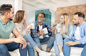 Group of millennial diverse friends chatting, having fun student party, spending weekend together at home