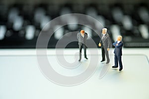 Group of miniature people businessmen collaborate help and work as team