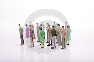 Group of miniature people over white background.