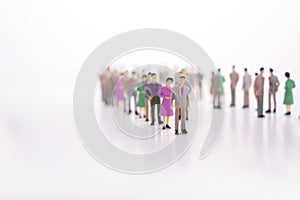 Group of miniature people over white background standing in line