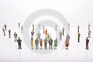 Group of miniature people over white background standing in line