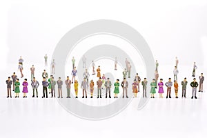 Group of miniature people over white background standing in line