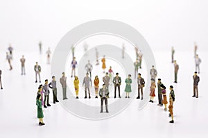 Group of miniature people over white background standing in line