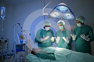 Group of mixed-races professional surgeons operating in hospital operating room , health care concept