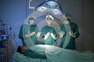 Group of mixed-races professional surgeons operating in hospital operating room , health care concept