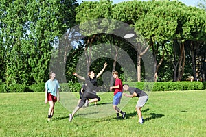 Group of mixed young teenagers people in casual wear playing with plastic flying disc game in a park oudoors. jumping woman catch